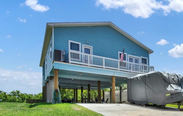 back of property featuring a carport and a balcony