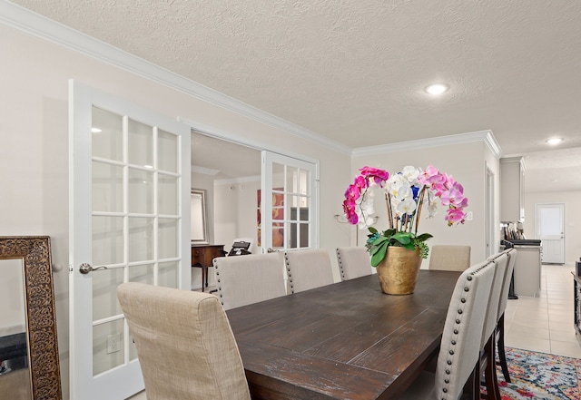 tiled dining area featuring crown molding, french doors, and a textured ceiling