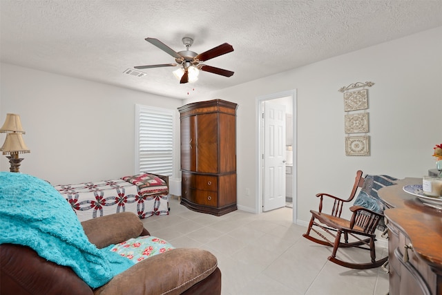 tiled bedroom with ceiling fan and a textured ceiling