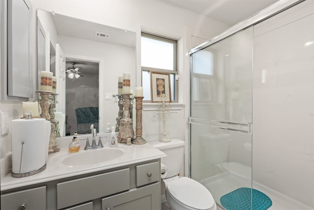 bathroom featuring an enclosed shower, ceiling fan, toilet, and vanity