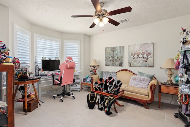 tiled office with a textured ceiling and ceiling fan