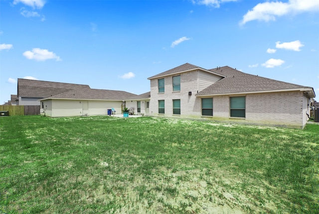 rear view of property featuring a lawn