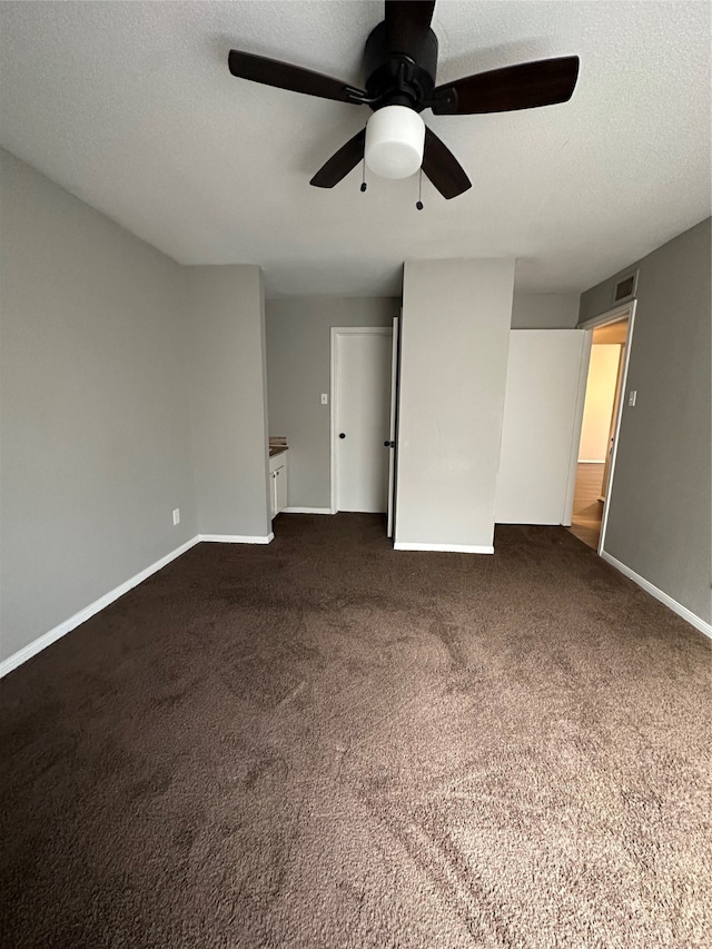 unfurnished bedroom featuring ceiling fan, carpet, and a textured ceiling