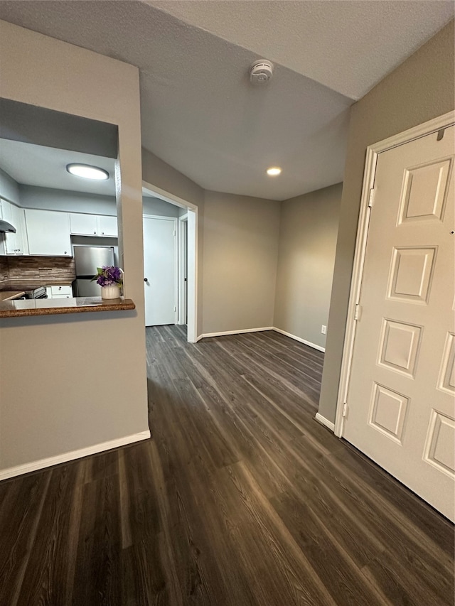 unfurnished living room featuring a textured ceiling and hardwood / wood-style floors