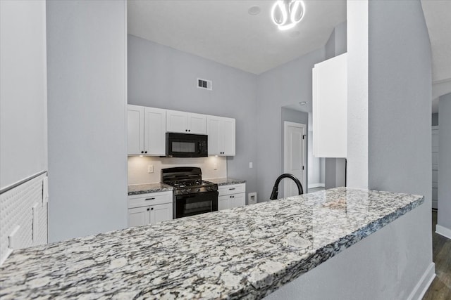 kitchen featuring black appliances, dark hardwood / wood-style floors, white cabinetry, and kitchen peninsula