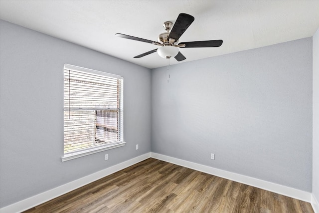 empty room featuring ceiling fan, a healthy amount of sunlight, and wood-type flooring