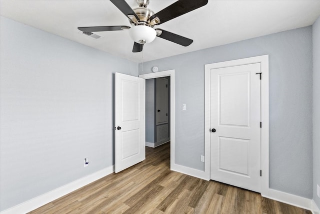 unfurnished bedroom with ceiling fan and wood-type flooring