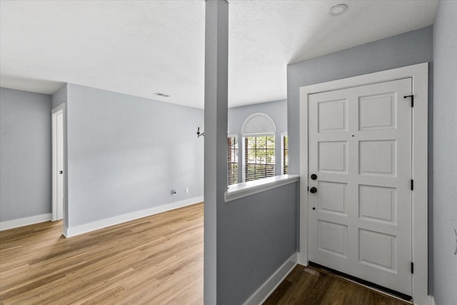 doorway to outside featuring wood-type flooring and a textured ceiling