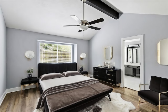 bedroom with hardwood / wood-style floors, vaulted ceiling with beams, ceiling fan, and ensuite bath