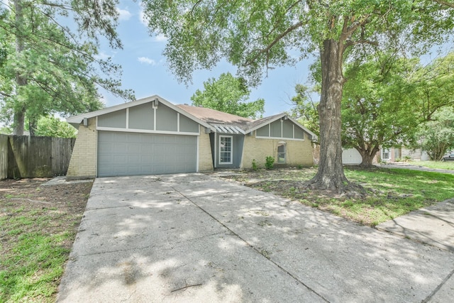 view of front facade with concrete driveway, brick siding, an attached garage, and fence