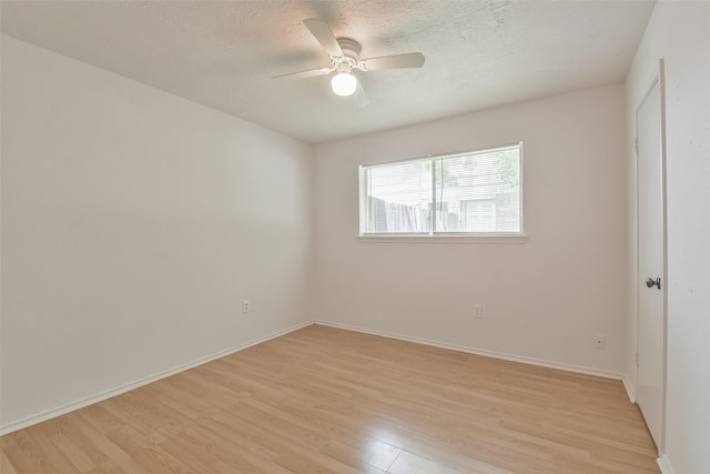 unfurnished room featuring light wood-type flooring, ceiling fan, a textured ceiling, and baseboards