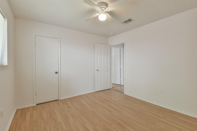 unfurnished bedroom featuring a ceiling fan, light wood-type flooring, visible vents, and baseboards