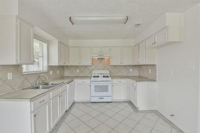 kitchen featuring white cabinets, tasteful backsplash, sink, and white appliances