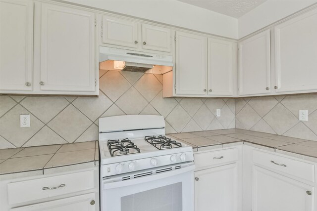 kitchen with decorative backsplash, white range with gas stovetop, and white cabinetry