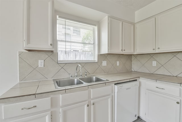 kitchen featuring decorative backsplash, white cabinetry, white dishwasher, tile countertops, and sink