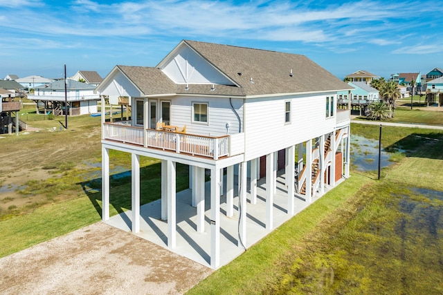 rear view of house with a patio area, a wooden deck, and a lawn