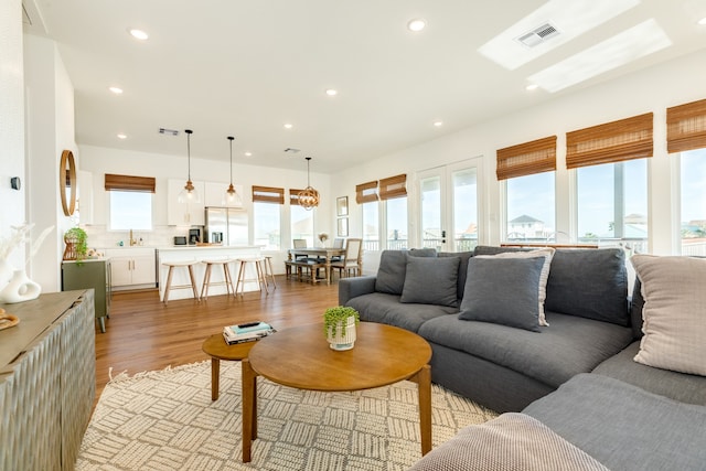 living room featuring french doors and light wood-type flooring