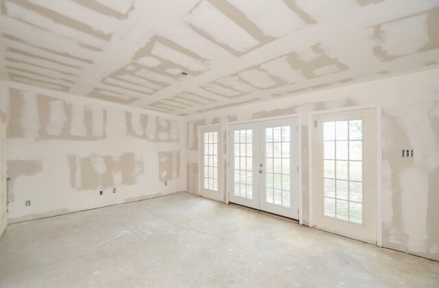 spare room with concrete floors and french doors