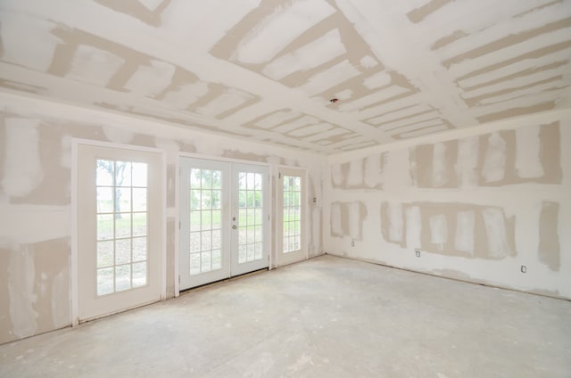 unfurnished room featuring concrete floors and french doors