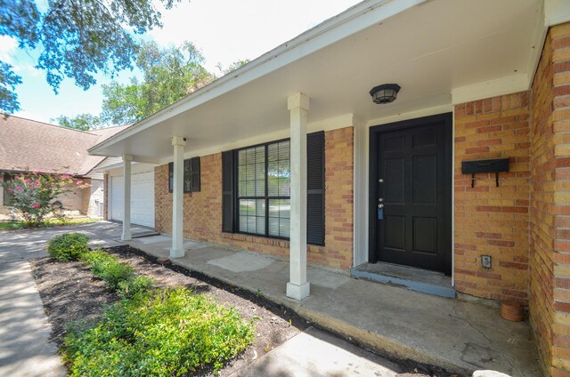 entrance to property with covered porch and a garage