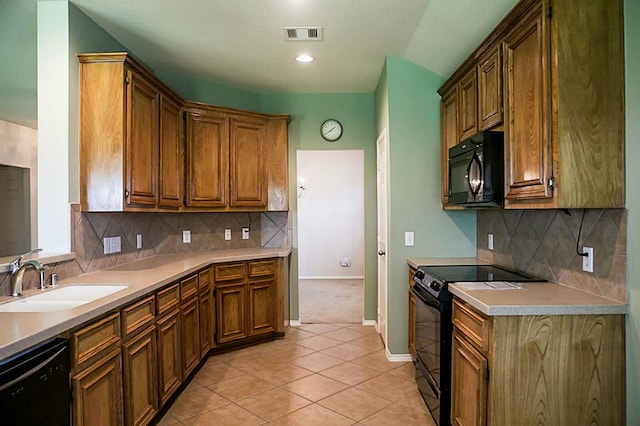 kitchen with sink, black appliances, light colored carpet, and tasteful backsplash