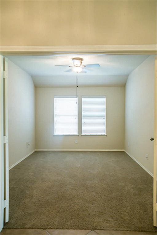 carpeted empty room featuring ceiling fan and vaulted ceiling