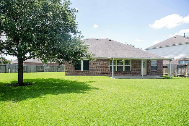 rear view of house with a patio area and a yard