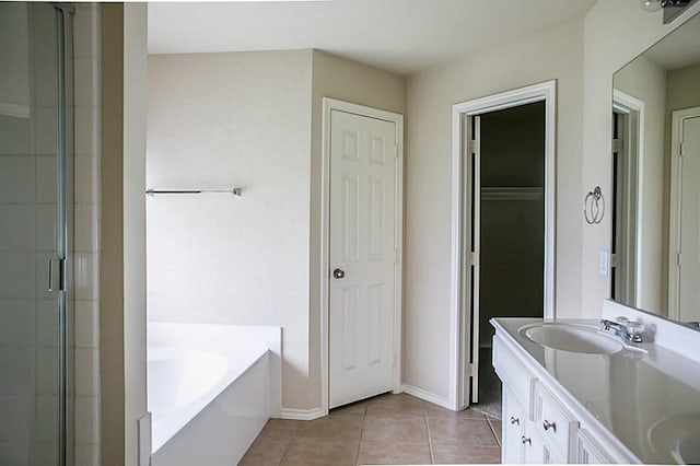 bathroom featuring a tub to relax in, double vanity, and tile patterned floors