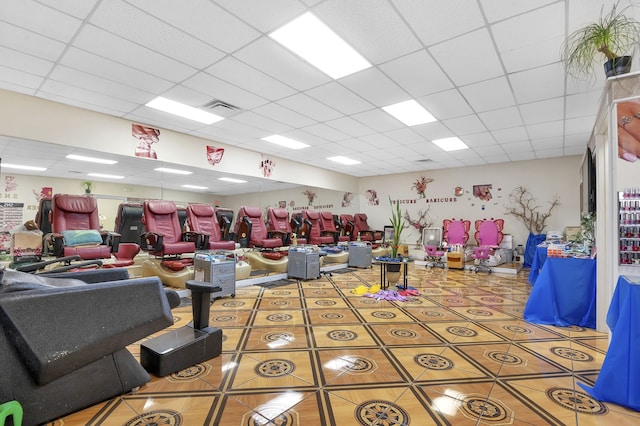 interior space featuring light tile patterned floors and a drop ceiling