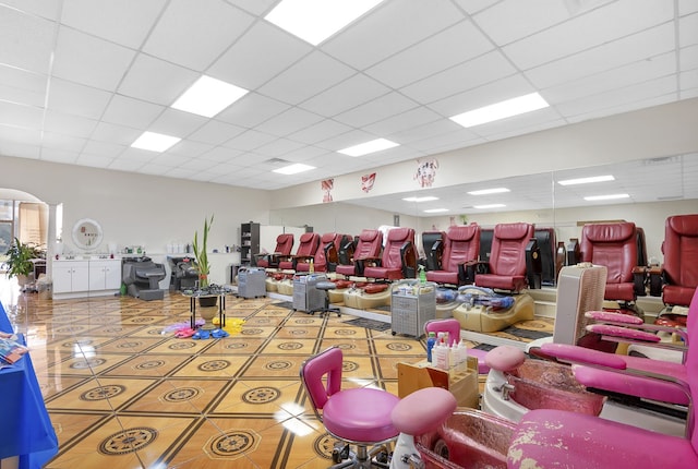 interior space featuring light tile patterned flooring and a paneled ceiling