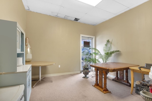 carpeted office space with a paneled ceiling