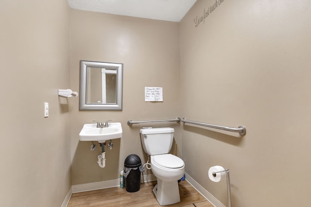 bathroom with sink, toilet, and wood-type flooring