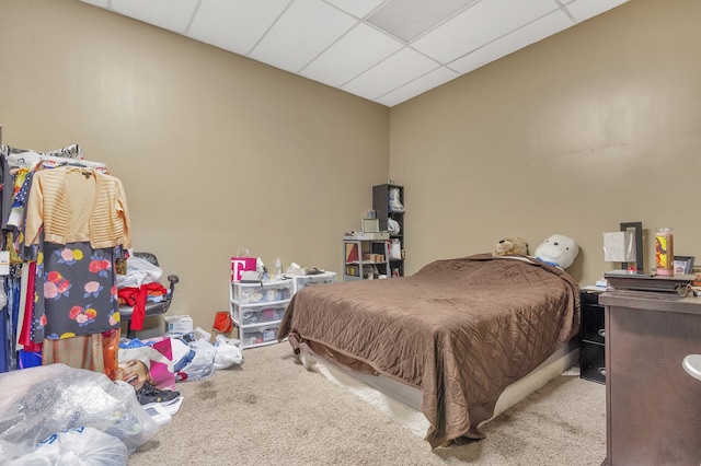 carpeted bedroom featuring a drop ceiling