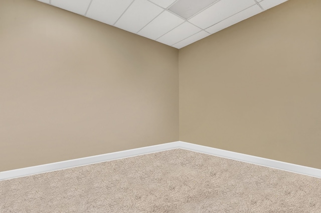 carpeted empty room with a drop ceiling