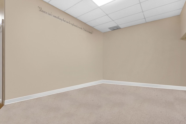 carpeted spare room featuring a paneled ceiling