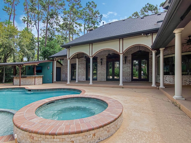 view of pool featuring a pool with connected hot tub, a patio, and french doors