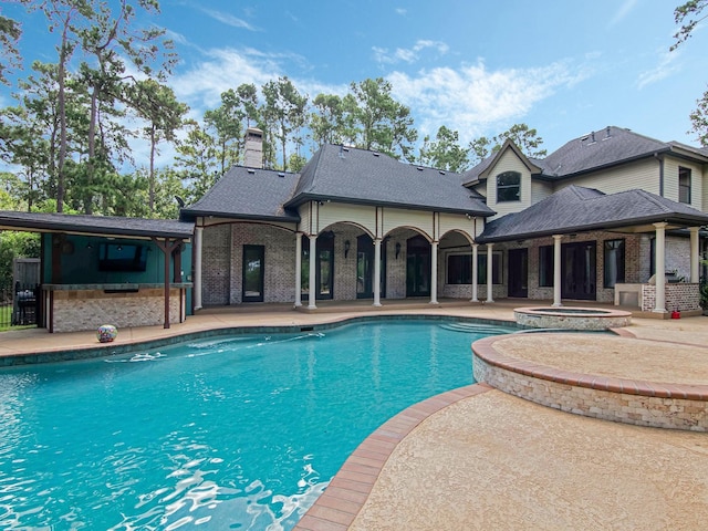 view of swimming pool with a pool with connected hot tub, a patio area, and outdoor dry bar