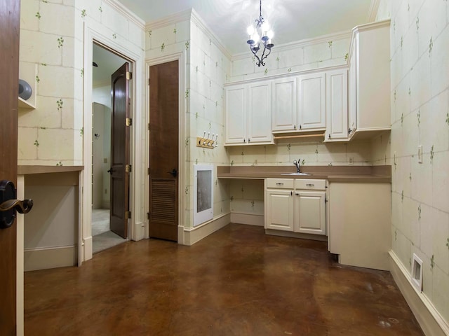 kitchen with crown molding, pendant lighting, sink, and white cabinets