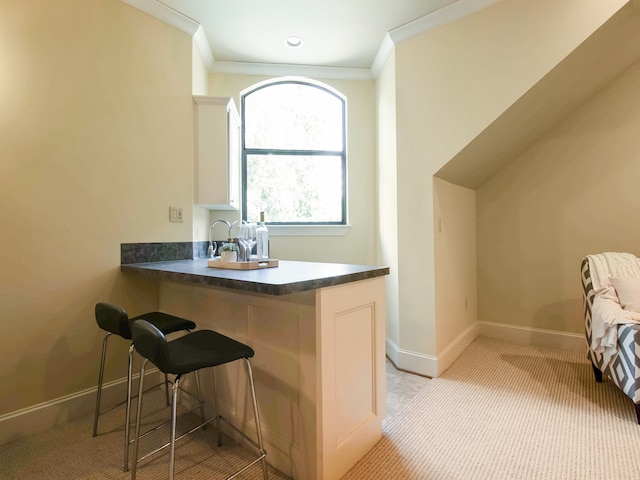 bar featuring crown molding, light colored carpet, and white cabinets