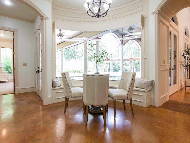 dining room with baseboards, concrete floors, ornamental molding, and a decorative wall