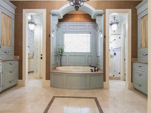 bathroom with wallpapered walls, a stall shower, baseboards, tile patterned floors, and a garden tub