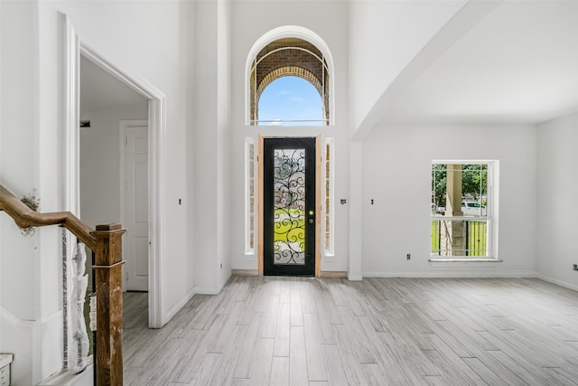 entryway with light wood-type flooring and a high ceiling