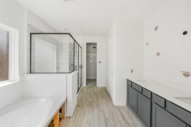 bathroom featuring shower with separate bathtub, hardwood / wood-style floors, and vanity