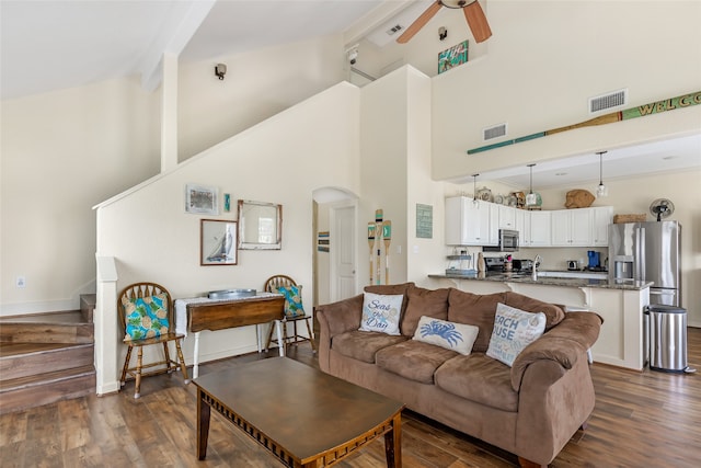 living room with beam ceiling, high vaulted ceiling, and dark wood-type flooring