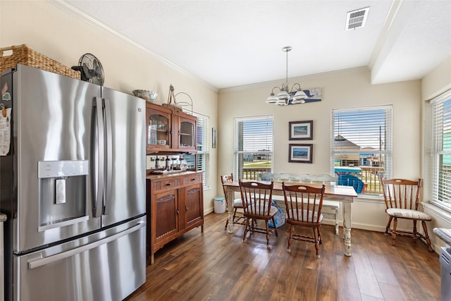 kitchen featuring hanging light fixtures, an inviting chandelier, dark wood-type flooring, stainless steel fridge, and crown molding