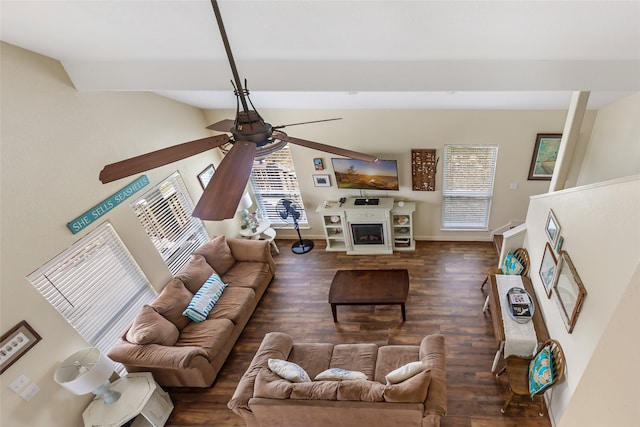 living room featuring a wealth of natural light, ceiling fan, dark hardwood / wood-style floors, and a fireplace