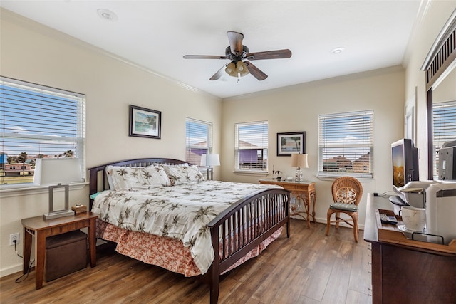 bedroom featuring hardwood / wood-style floors, crown molding, and ceiling fan