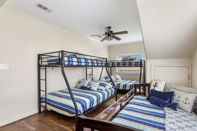 bedroom with hardwood / wood-style flooring, ornamental molding, and ceiling fan