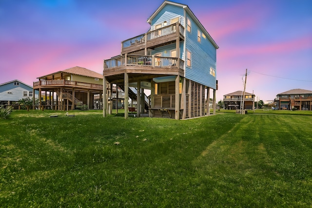 back house at dusk with a yard and a deck