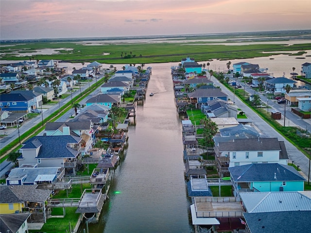 aerial view at dusk featuring a water view